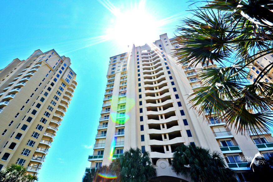 Ground level view of Beach Colony Resort tower on Sunny day